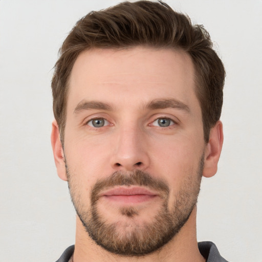 Joyful white young-adult male with short  brown hair and grey eyes