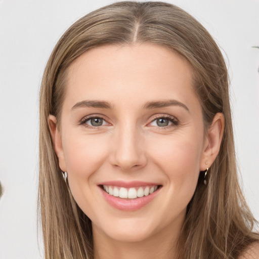 Joyful white young-adult female with long  brown hair and grey eyes