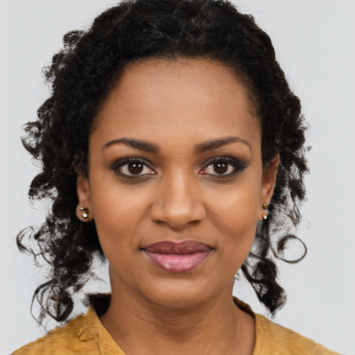 Joyful black young-adult female with long  brown hair and brown eyes