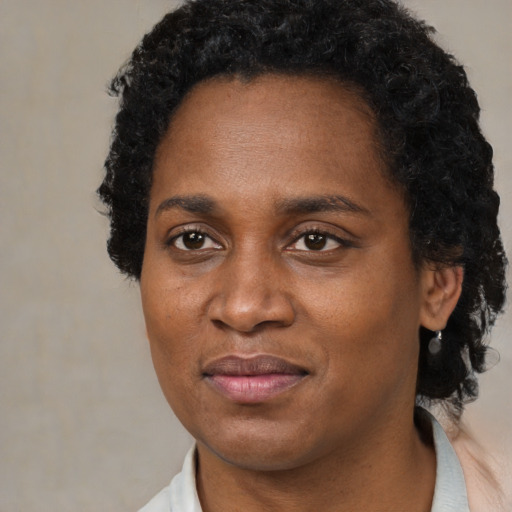 Joyful black adult female with short  black hair and brown eyes
