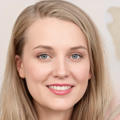 Joyful white young-adult female with long  brown hair and blue eyes