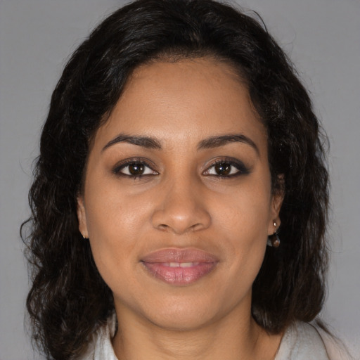 Joyful black young-adult female with long  brown hair and brown eyes