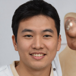 Joyful asian young-adult male with short  brown hair and brown eyes