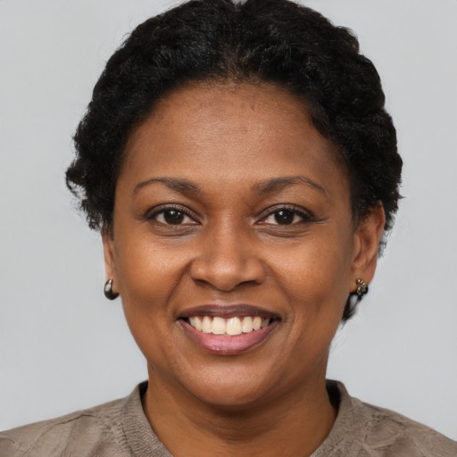 Joyful black adult female with short  brown hair and brown eyes