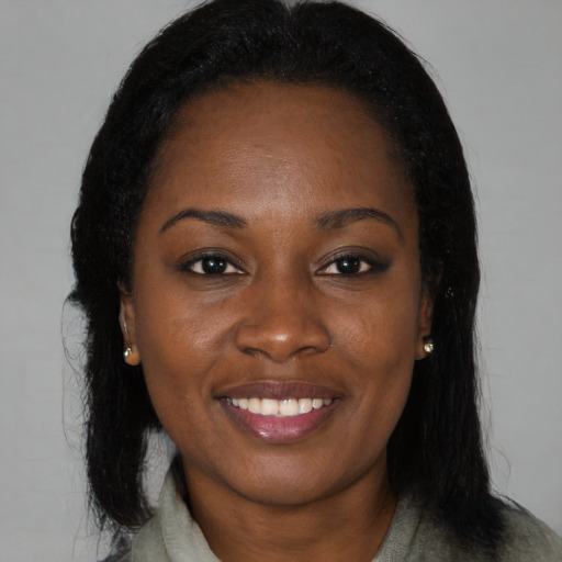 Joyful black young-adult female with long  black hair and brown eyes