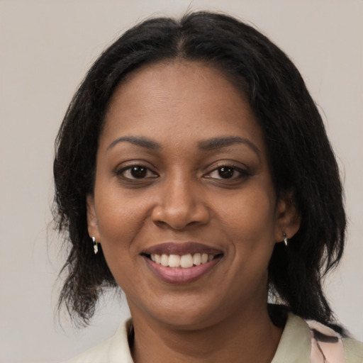 Joyful black young-adult female with medium  brown hair and brown eyes