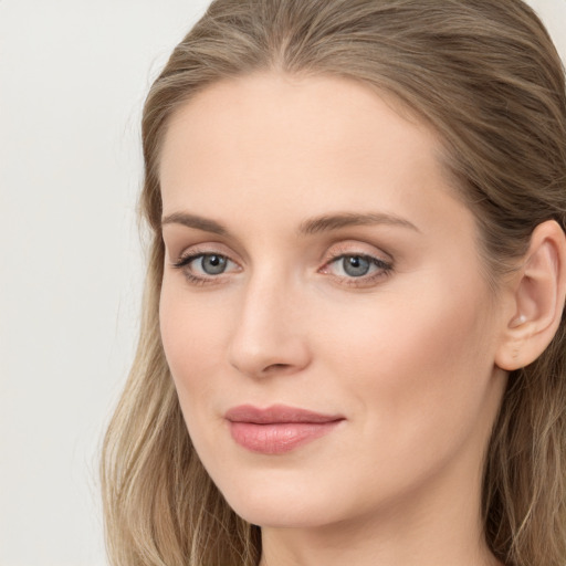 Joyful white young-adult female with long  brown hair and blue eyes