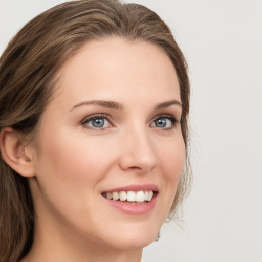 Joyful white young-adult female with long  brown hair and grey eyes