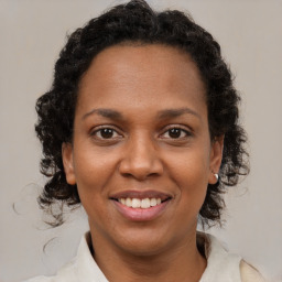 Joyful black adult female with medium  brown hair and brown eyes