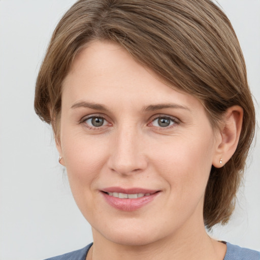 Joyful white young-adult female with medium  brown hair and grey eyes