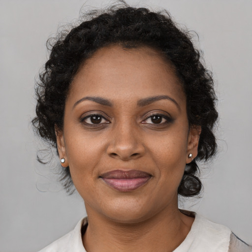 Joyful black young-adult female with medium  brown hair and brown eyes
