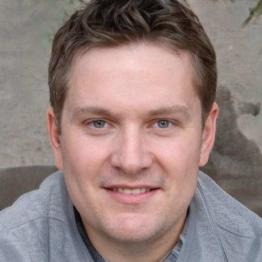 Joyful white adult male with short  brown hair and blue eyes