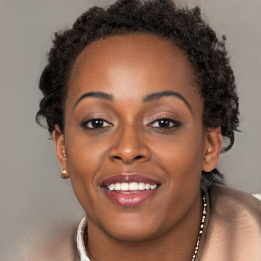 Joyful black young-adult female with long  brown hair and brown eyes