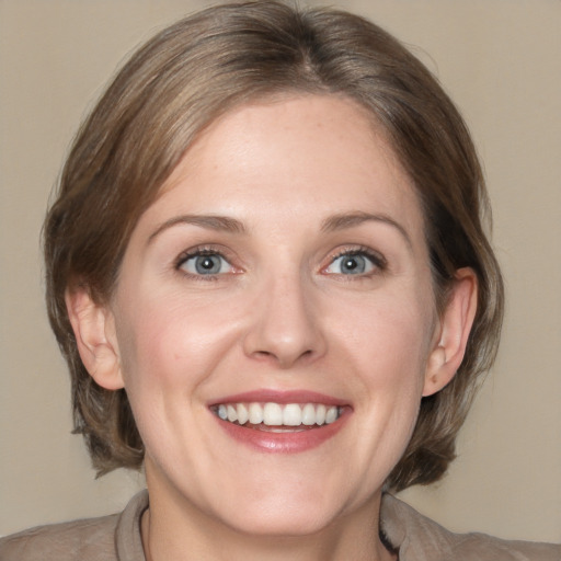 Joyful white adult female with medium  brown hair and grey eyes