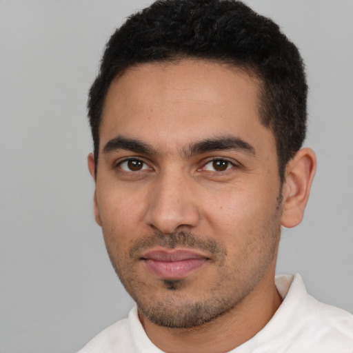 Joyful latino young-adult male with short  black hair and brown eyes