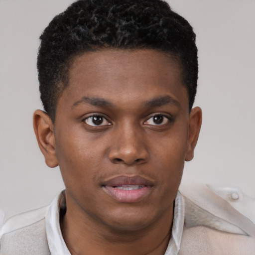 Joyful black young-adult male with short  brown hair and brown eyes