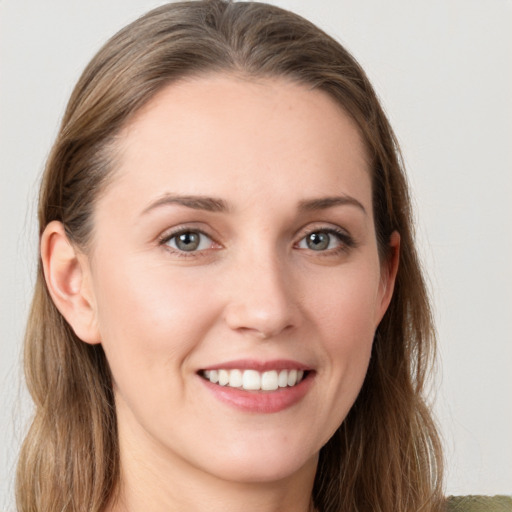 Joyful white young-adult female with long  brown hair and grey eyes