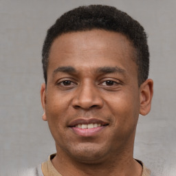 Joyful latino young-adult male with short  brown hair and brown eyes