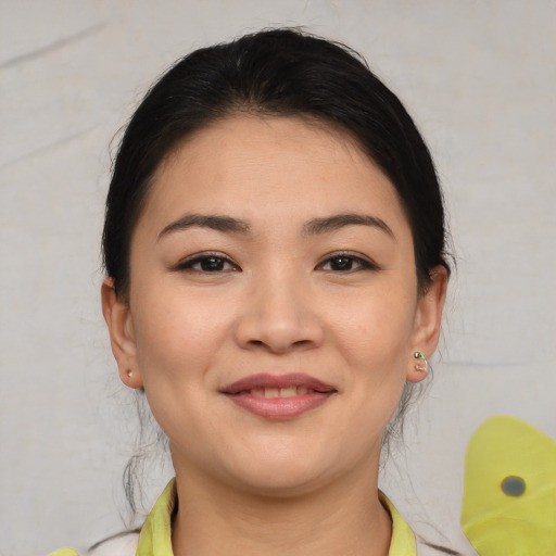 Joyful asian young-adult female with medium  brown hair and brown eyes