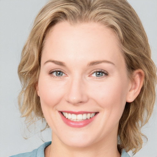 Joyful white young-adult female with medium  brown hair and blue eyes