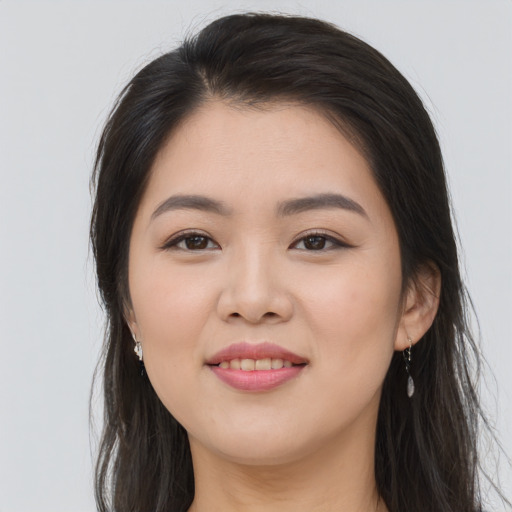 Joyful asian young-adult female with long  brown hair and brown eyes