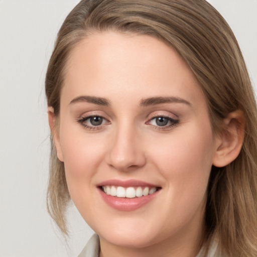 Joyful white young-adult female with long  brown hair and blue eyes