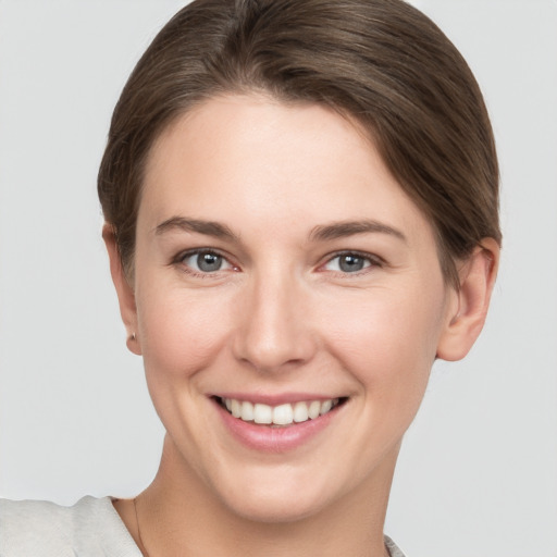 Joyful white young-adult female with short  brown hair and grey eyes