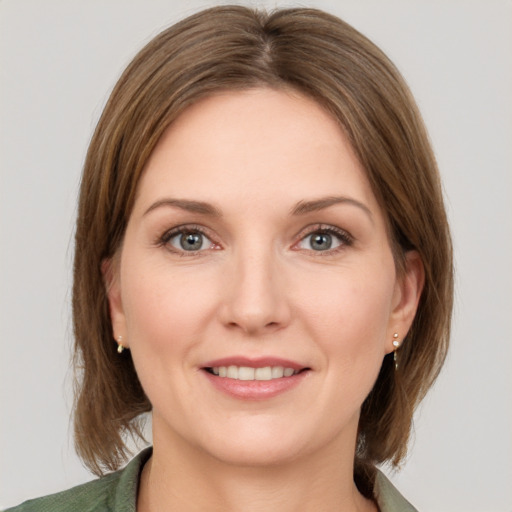 Joyful white young-adult female with medium  brown hair and grey eyes