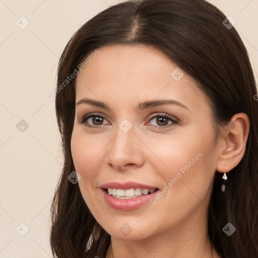 Joyful white young-adult female with long  brown hair and brown eyes