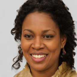 Joyful black adult female with long  brown hair and brown eyes