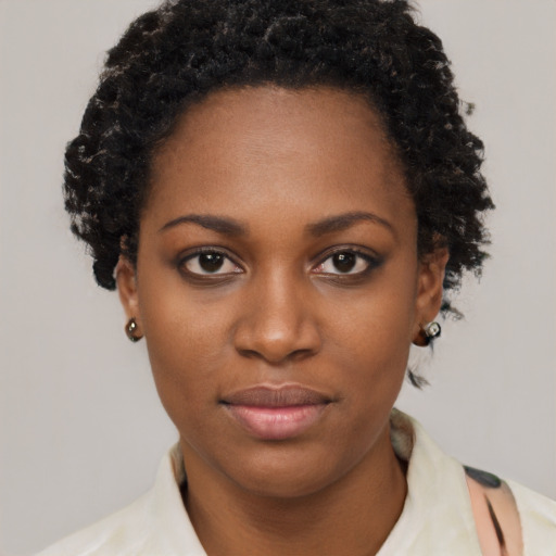 Joyful black young-adult female with short  black hair and brown eyes