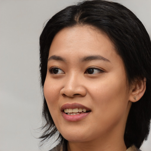 Joyful asian young-adult female with medium  black hair and brown eyes