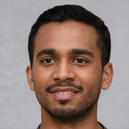 Joyful latino young-adult male with short  black hair and brown eyes