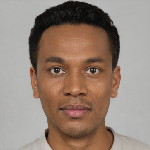 Joyful black young-adult male with short  black hair and brown eyes