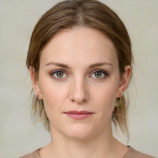 Joyful white young-adult female with medium  brown hair and green eyes