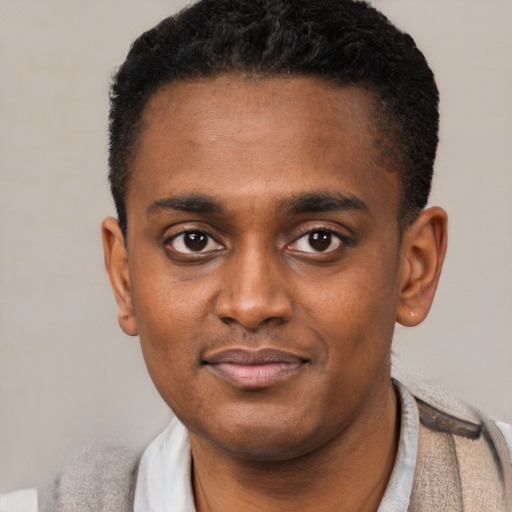 Joyful black young-adult male with short  black hair and brown eyes