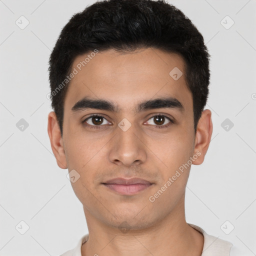 Joyful latino young-adult male with short  black hair and brown eyes