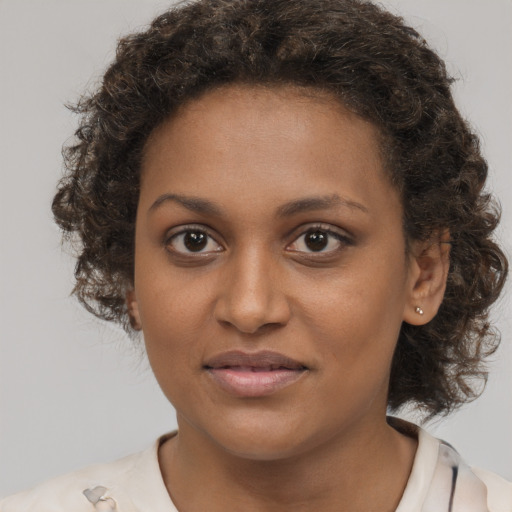 Joyful black young-adult female with medium  brown hair and brown eyes