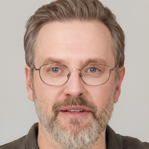 Joyful white adult male with short  brown hair and blue eyes