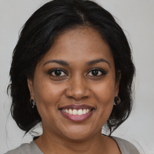 Joyful black young-adult female with medium  brown hair and brown eyes