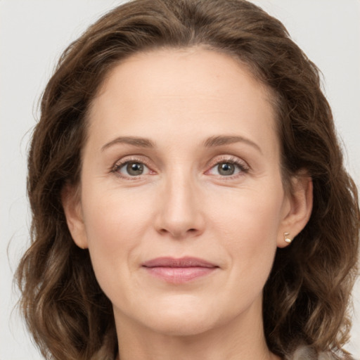 Joyful white adult female with medium  brown hair and grey eyes