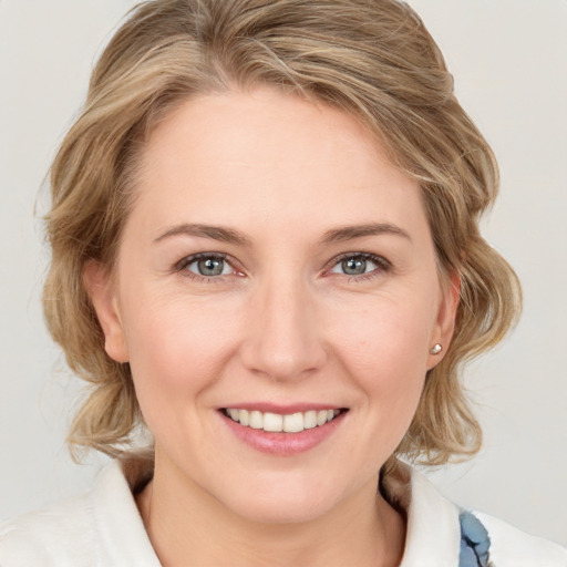 Joyful white young-adult female with medium  brown hair and blue eyes