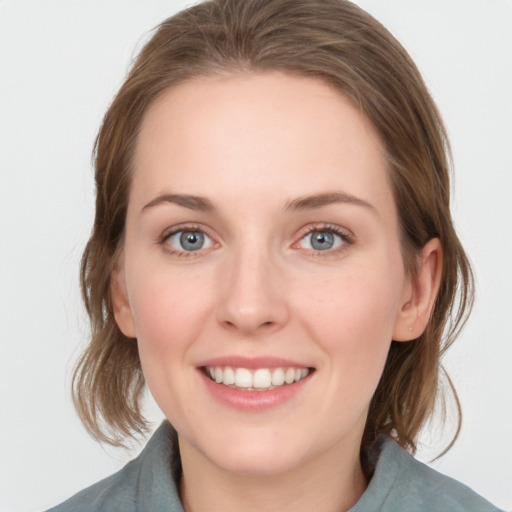 Joyful white young-adult female with medium  brown hair and blue eyes