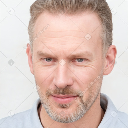 Joyful white adult male with short  brown hair and grey eyes