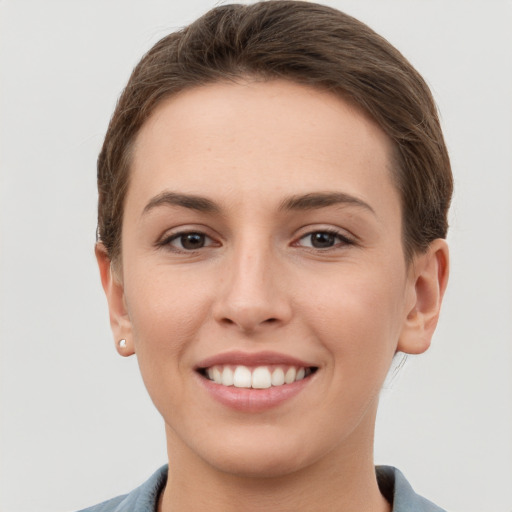 Joyful white young-adult female with short  brown hair and grey eyes