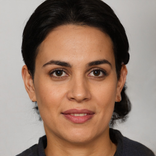 Joyful white adult female with medium  black hair and brown eyes