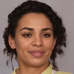 Joyful black adult female with medium  brown hair and brown eyes