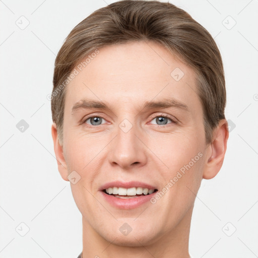 Joyful white young-adult male with short  brown hair and grey eyes