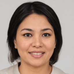 Joyful latino young-adult female with medium  brown hair and brown eyes