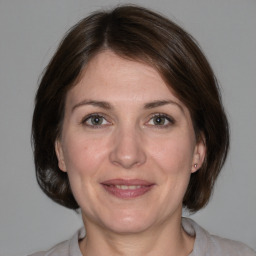 Joyful white adult female with medium  brown hair and grey eyes